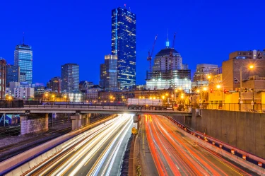 Boston-area Massachusetts skyline at night with highway light trails